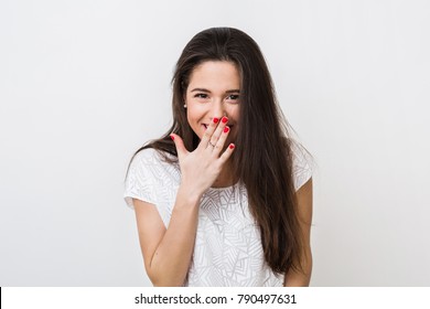 Portrait Of Young Pretty Woman Smiling, Giggling, Shy, Flirty, Hiding Her Smile With Hand, Isolated On White Studio Background