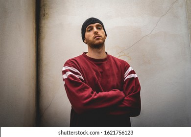 Portrait Of Young Rapper Posing In Front Of A White Wall In The Suburbs