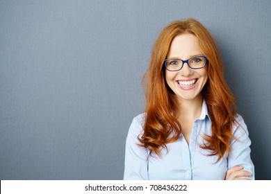 Portrait of young red-haired woman wearing glasses against blue background - Powered by Shutterstock