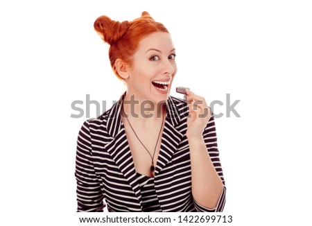Portrait of a young redhead girl holding showing loving chocolate woman smiling wearing striped black white jacket with 2 buns up hairdo isolated on white background wall. Mixed race, Irish  Hispanic 