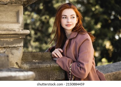 Portrait Of Young Redhead Woman In Coat Looking Away Outside