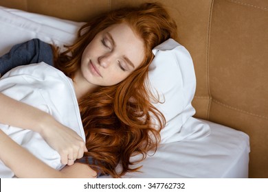 Portrait of a young redhead woman sleeping in the bed at home - Powered by Shutterstock