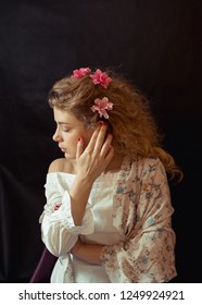 Portrait Of A Young Romantic Woman With Blond Curly Hair In A Vintage Floral Dress Sitting Over Black Background. Close Up Of Woman