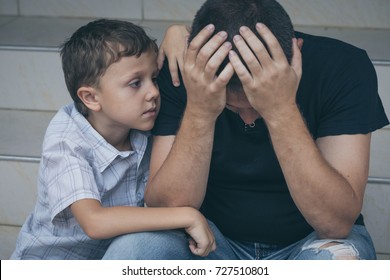 Portrait of young sad little boy and father sitting outdoors at the day time. Concept of sorrow. - Powered by Shutterstock