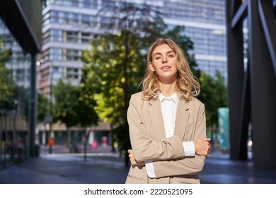 Portrait Of Young Saleswoman, Confident Businesswoman In Suit, Cross Arms On Chest, Standing In Power Pose On Street Near Office Buildings.