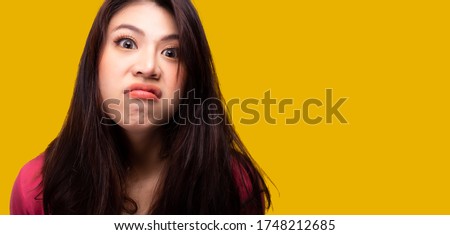 Portrait young scowling asian woman Offended asia girl get insulted expression, scowl face, gesture her lips in discontent. She is jealous or envy girl. yellow background, copy space