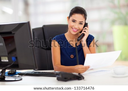 portrait of young secretary answering telephone