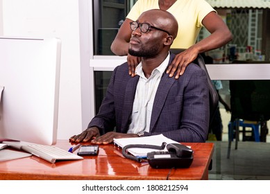 portrait of a young secretary massaging the shoulders of her boss at the workplace in the office.