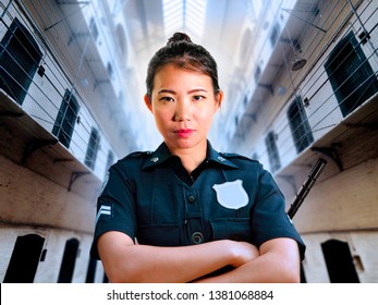 Portrait Of Young Serious And Attractive Asian Chinese Guard Woman Standing At State Penitentiary Prison Hall Wearing Police Uniform In Crime Punishment And Law Enforcement Concept