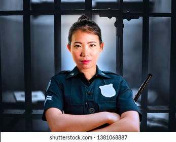 Portrait Of Young Serious And Attractive Asian Chinese Guard Woman Standing On Cell At State Penitentiary Wearing Police Uniform In Crime Prison Punishment And Law Enforcement Concept