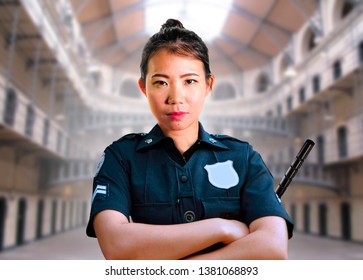 Portrait Of Young Serious And Attractive Asian American Guard Woman Standing At State Penitentiary Prison Hall Wearing Police Uniform In Crime Punishment And Law Enforcement Concept