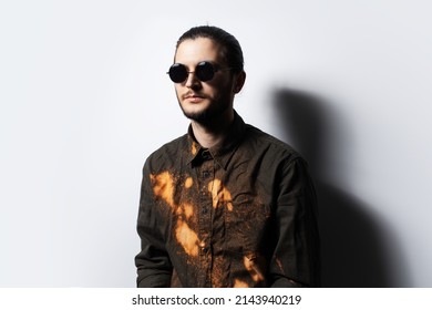 Portrait Of Young Serious Man Wearing Round Sunglasses, White Background.