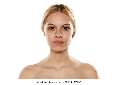portrait of a young serious woman without makeup on a white background
