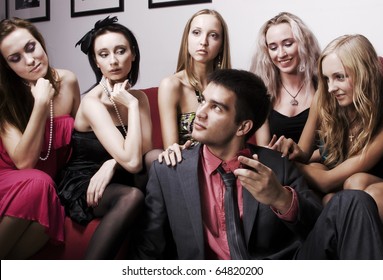 Portrait of young sexy lovelace man surrounded by hot women wanting of proposal from him