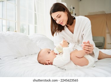 Portrait of a young single mother babysitter bottle feeding a small young child, infant, infant, newborn. Nutrition concept of breastfeeding and milk expression. - Powered by Shutterstock