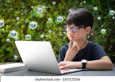 Portrait Of A Young Smart Asian Teen Student Boy Using Computer Laptop To Study About Cryptocurrency And Blockchain Data The Internet-based Virtual Electronic Money. Disruptive Technology, Bitcoin.