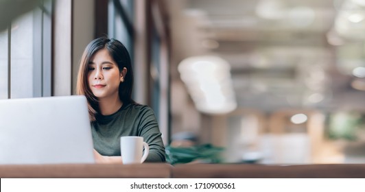 Portrait of Young Smart Asian Woman Freelance Online Working from Home with Laptop at Home Living Room in Coronavirus or Covid-19 Outbreak Situation - Healthcare and Social Distancing Concept - Shutterstock ID 1710900361