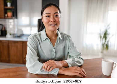 Portrait of a young smiling Asian woman sitting at home - Shutterstock ID 2195274879