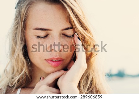 Portrait Of Young Smiling Beautiful Woman with a Headache, Touching Her Face by Hands