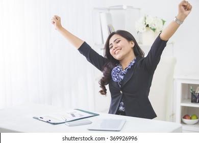 Portrait Of Young Smiling Business Woman Raise Arm After Finishing Her Work