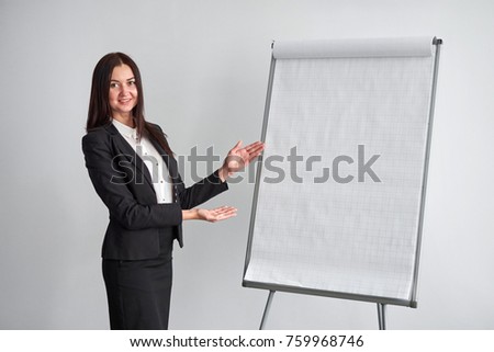 Portrait of young smiling businesswoman standing by flipchart in office