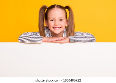 Portrait of young smiling cheerful positive little girl child kid hold hands on white billboard banner isolated on yellow color background - Powered by Shutterstock