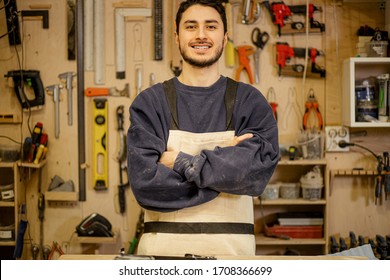 Portrait Of Young Smiling Confident Carpenter At Work Place, Handsome Caucasian Craftman Love Cutting Wood, Work In Factory