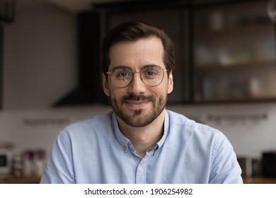 Portrait of young smiling handsome bearded man in glasses looking at camera chatting with wife friend by videocall. Millennial male team leader organize virtual meeting workshop with employees online