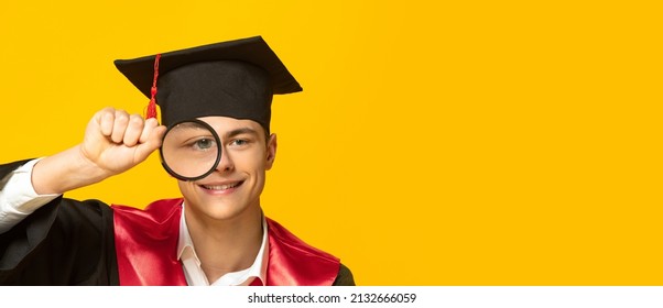 Portrait of young smiling man, student in graduation cap and gown looking in magnifying glass isolated on yellow studio background. Curious boy. Concept of education, studying, youth, lifestyle, exams - Powered by Shutterstock