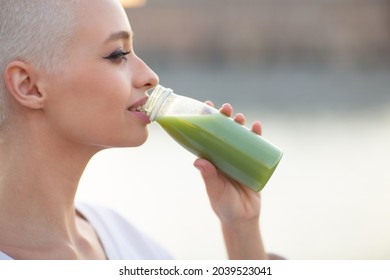 Portrait Of Young Smiling Millenial European Short Haired Woman With Green Smoothie. Beautiful Happy Blonde Girl Outdoor.