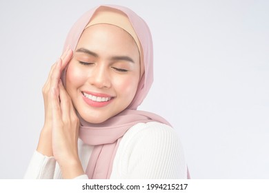 A Portrait Of Young Smiling Muslim Woman Wearing A Pink Hijab Over White Background Studio.