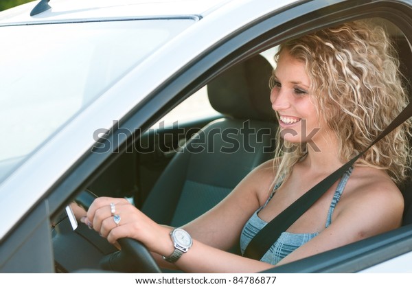 Portrait of young\
smiling person driving\
car