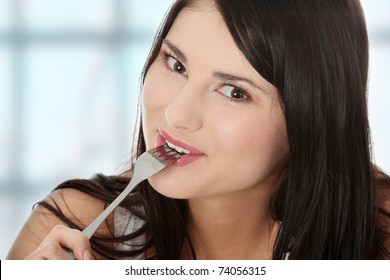 Portrait Of Young Smiling Woman With Fork In Her Mouth And (pleasure From Eating)