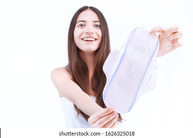 Portrait Of Young Smiling Woman Is Holding Disposable Sanitary Pad, Napkin, Towel For Absorbing Menstrual Blood. Critical Days And Women Health Concept. Personal Hygiene And Care Products. 