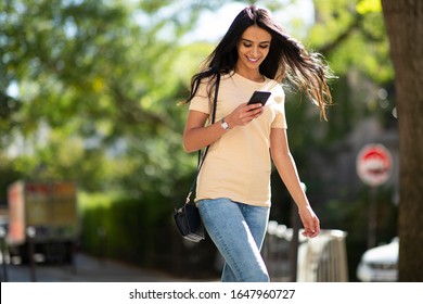 Portrait Young Smiling Woman Looking At Mobile Phone Outside 