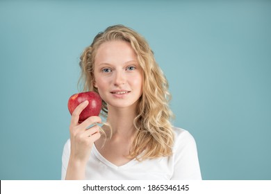 Portrait of young smiling woman with red apple. Fresh face, natural beauty, realistic. Clean young fresh skin without makeup and retouching. Healthy care