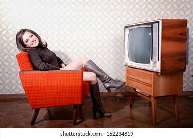 portrait of young smiling woman sitting in vintage room and watching tv, retro stylization, toned