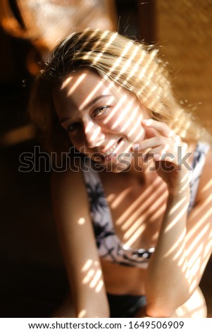 Similar – Young blonde woman portrait laughing outdoors sitting in a garden, and looking at camera.