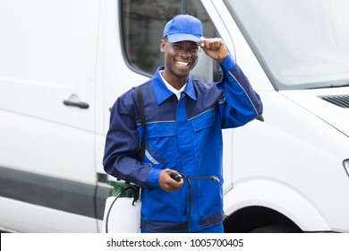 Portrait Of Young Smiling Worker With Pesticide Sprayer While Standing By Van