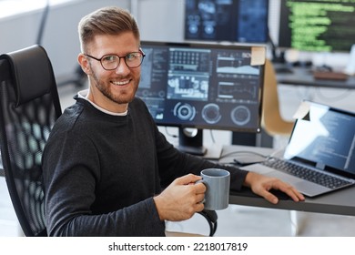 Portrait Of Young Software Engineer Smiling At Camera While Posing At Workplace In Office With Coffee Cup, Copy Space