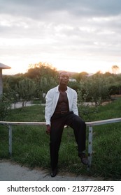 Portrait Of A Young South American Man Leaning On A Fence On Sunset