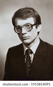 Portrait Of Young Soviet Guy With Glasses, In Jacket And Tie. Vintage Black And White Paper Photo, 1970s. Transferred Property, Family Archive. Outdated Quality