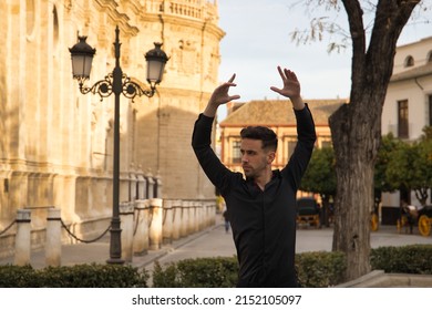 Portrait Of Young Spanish Man, Wearing Black Shirt And Pants, Dancing Flamenco In The Street. Typical Spanish Concept, Art, Dance, Culture, Tradition.