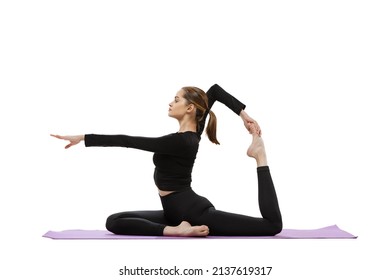 Portrait Of Young Sportive Woman In Black Tracksuit Doing Yoga And Stretching Exercises On Purple Mat Isolated Over White Studio Background. Following Sportive Lifestyle. Concept Of Fitness, Health