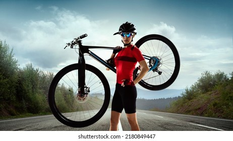 Portrait of young sportive woman, cyclist holding bike in her shoulder. Preparing to travel. Road view. Concept of sport, strength, action, motion, vitality, health. Copy space for ad - Powered by Shutterstock