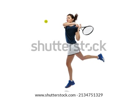 Portrait of young sportive woman, tennis player playing tennis isolated on white background. Healthy lifestyle, fitness, sport, exercise concept. Female athlete in motion, action or movement