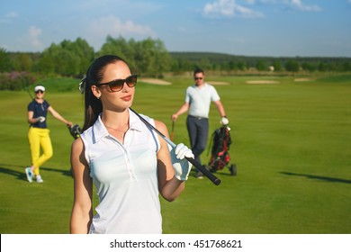 Portrait of young sportive women golfer playing golf with friends at sunny day