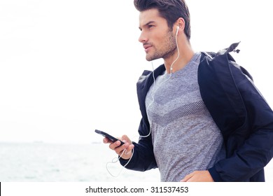 Portrait Of A Young Sports Man Running With Headphones