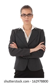 Portrait of young strict businesswoman with arms folded, looking at camera.