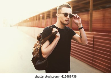 Portrait of young stylish man with bag in the street, life style